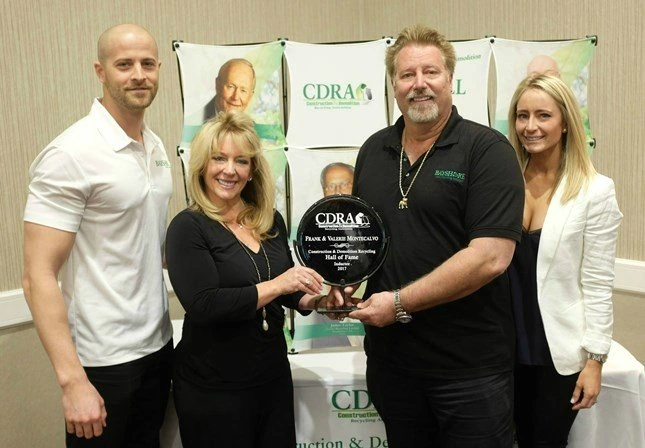 Group photo at an awards event with Frank Montecalvo holding a hall of fame plaque