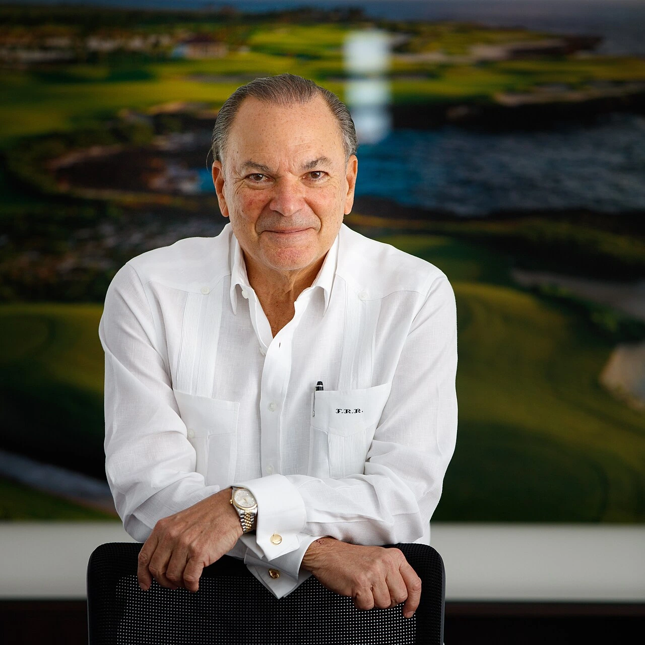 Portrait photo of Frank Elías Rainieri Kuret seated in a white shirt, looking at the camera.