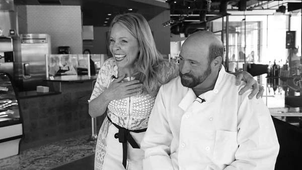 Frank Bonanno seated in a restaurant, pictured with a woman, in a black-and-white editorial-style photo